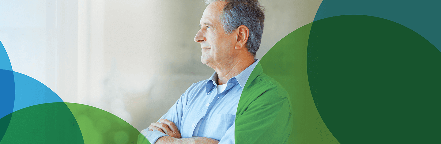 Image of an older man with crossed arms and blue shirt looking into the distance. Blue and green circles border him